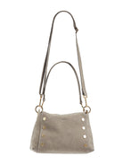 Gray-taupe textured leather shoulder bag with gold hardware. Features a top handle, long adjustable strap, and studs on...