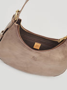 Small, curved, metallic taupe leather shoulder bag; gold zipper, dark brown lining, and embossed logo.