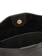 Black leather bag interior with gold snap closure on flap. Features black suede lining and an embossed logo.