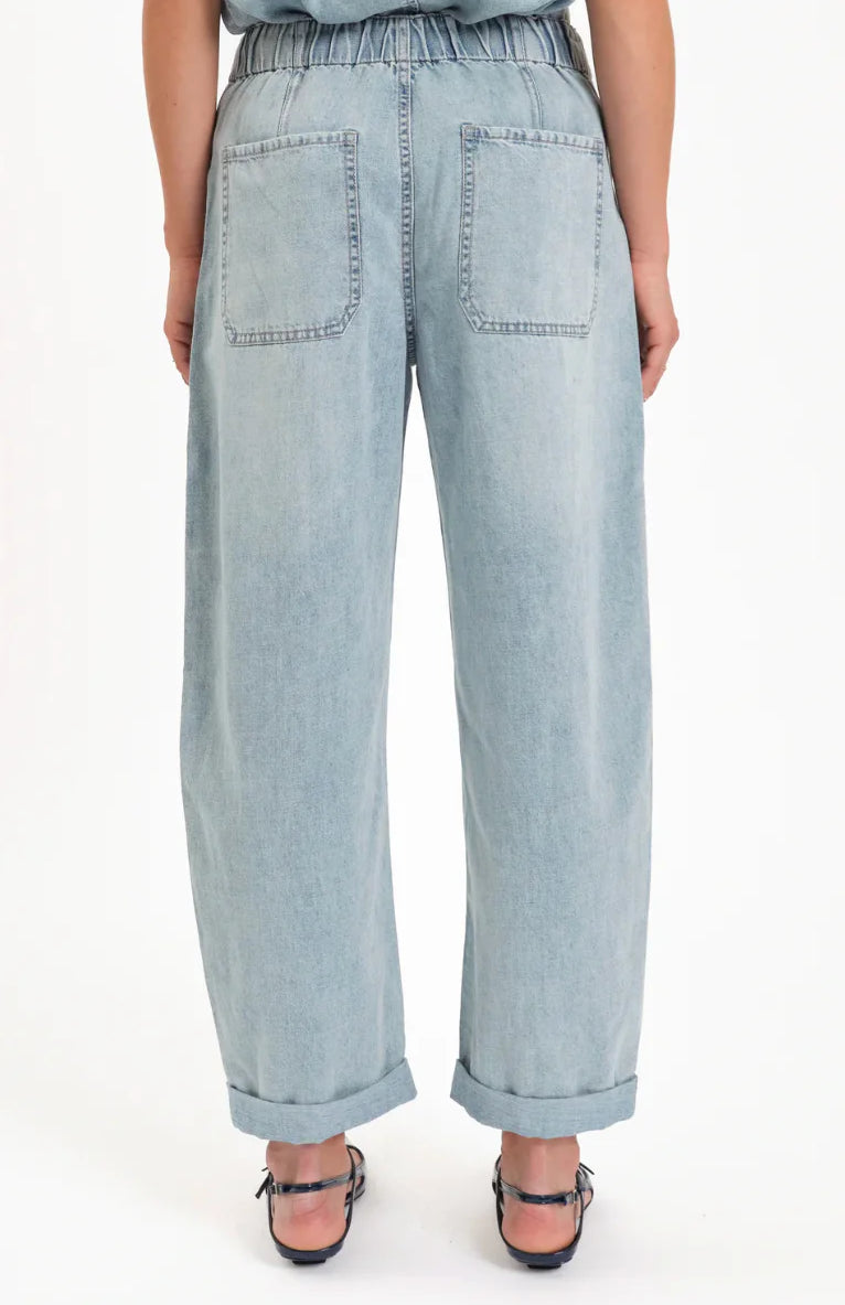 Light wash denim barrel leg jeans, back view, with an elastic waist, two large patch pockets, and cuffed ankles.