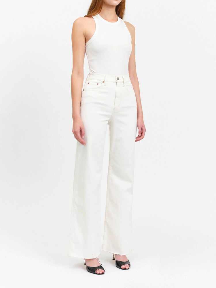 Off-white, wide-leg jeans; frayed hem. Model wears a white top and black heels.