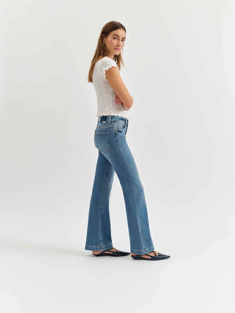 Medium blue mid-rise flare jeans, modeled from hip to floor, showing standard pockets and belt loops.
