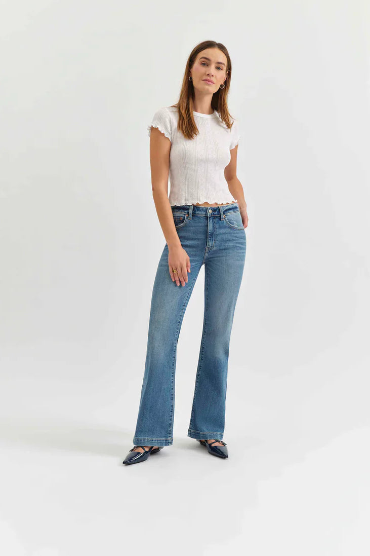 Medium blue mid-rise flare jeans worn by a model.