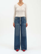 Medium blue wash wide-leg jeans with an elastic waist, white drawstring, and light fading on thighs.