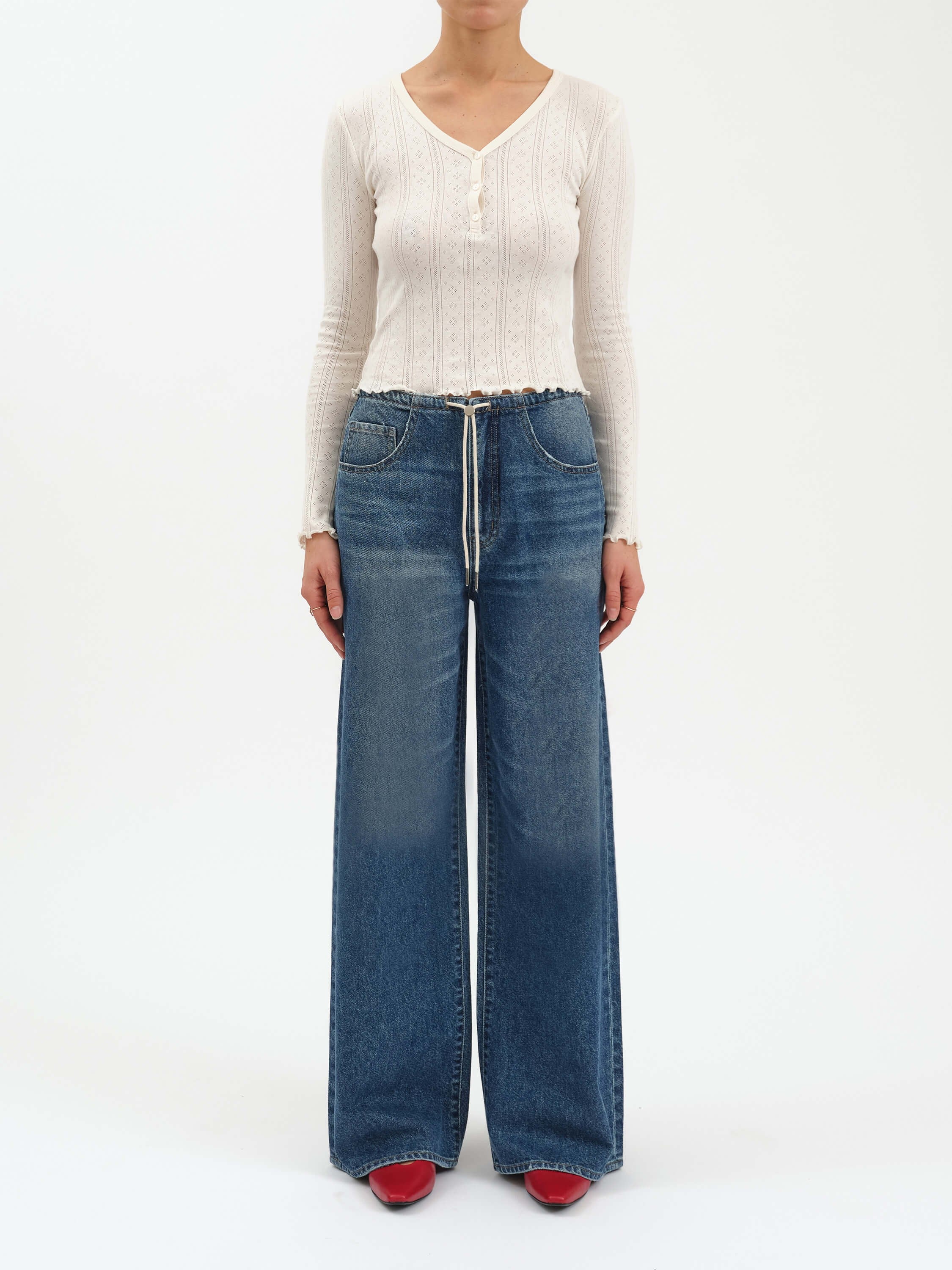 Medium blue wash wide-leg jeans with an elastic waist, white drawstring, and light fading on thighs.