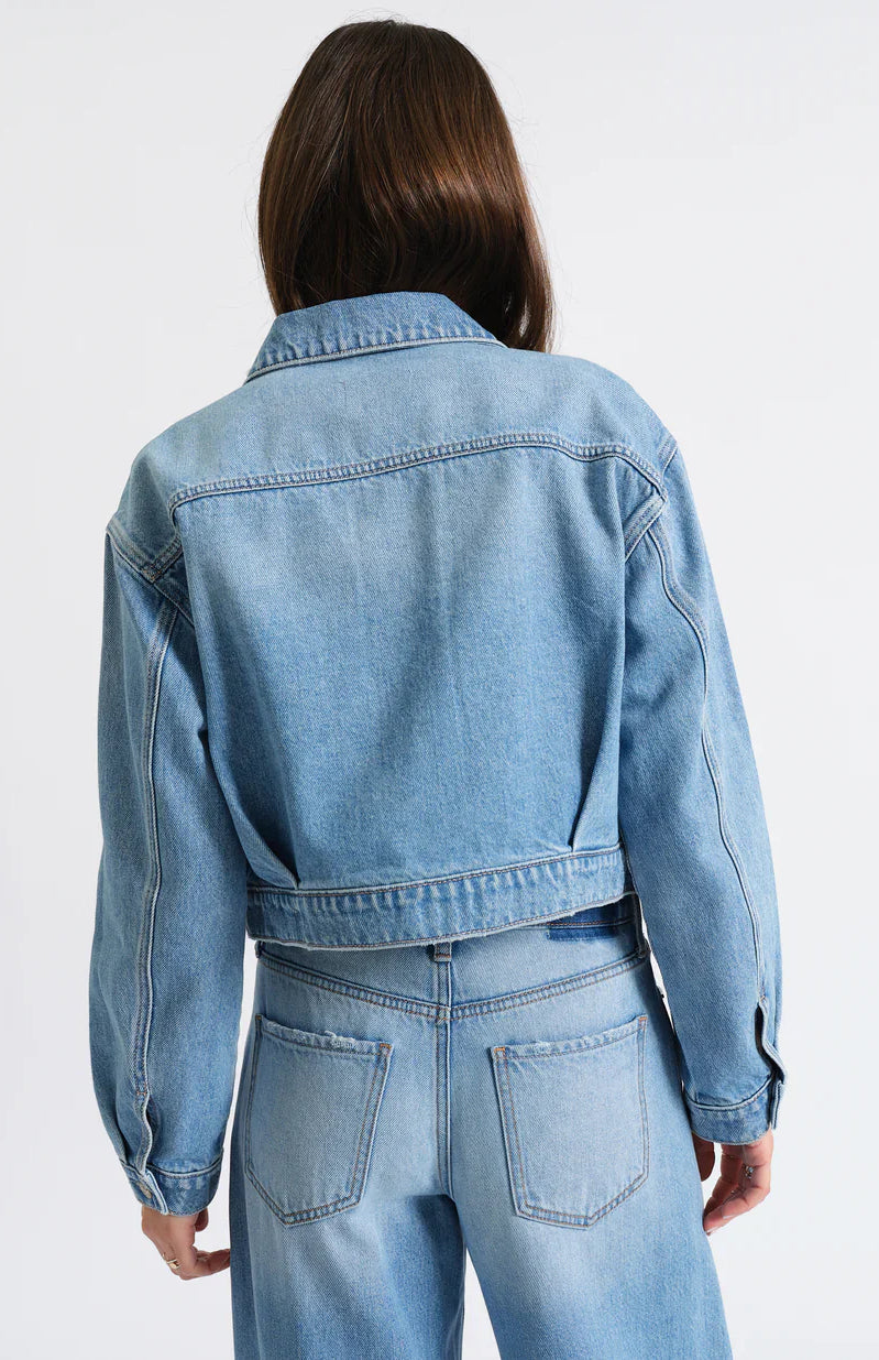 Light blue cropped denim jacket, back view. Features a collar, yoke seam, and waistband.