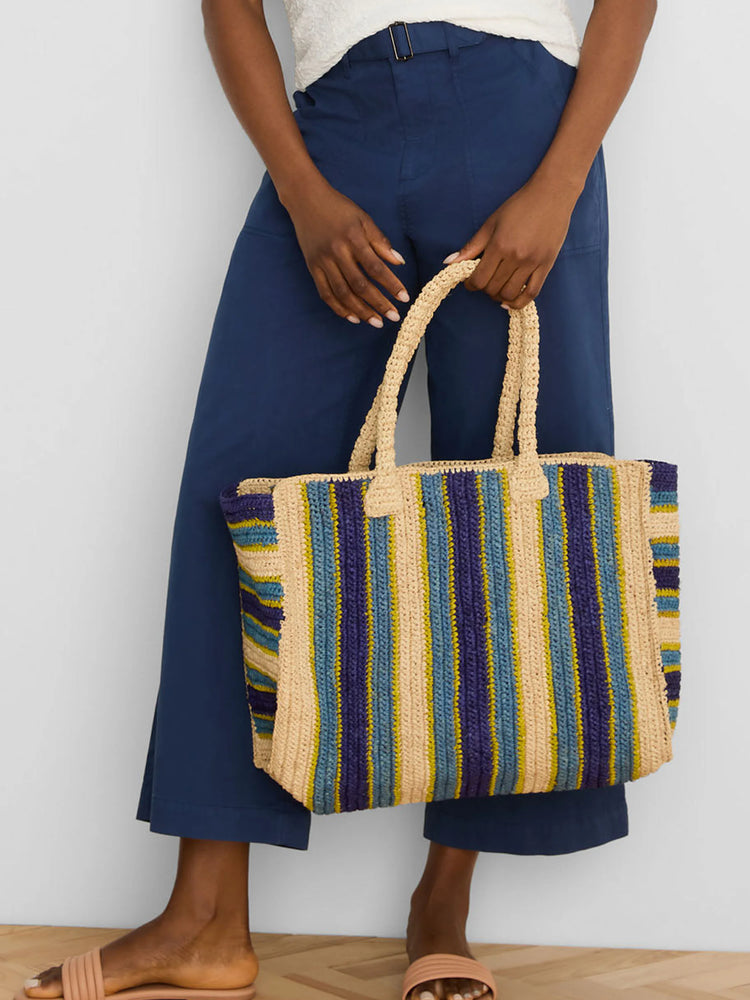Woven tote with beige, navy, light blue, and lime green vertical stripes. Woven handles.