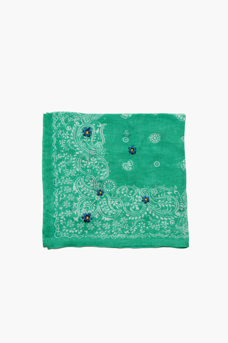 Folded green bandana with white paisley print and three small blue embroidered flowers with yellow centers.