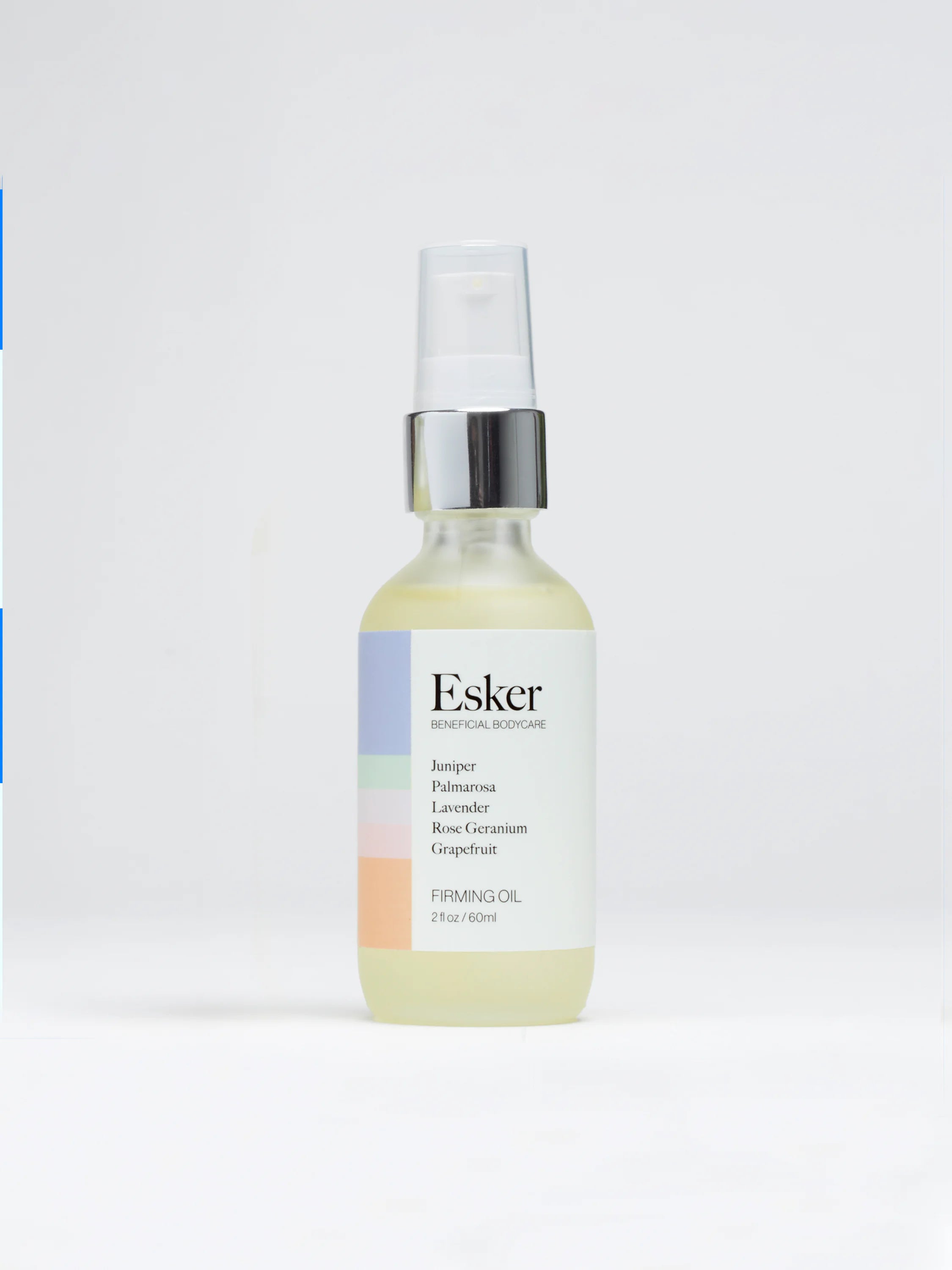 Clear glass bottle of pale yellow oil, silver top, white label with pastel stripes & black text.