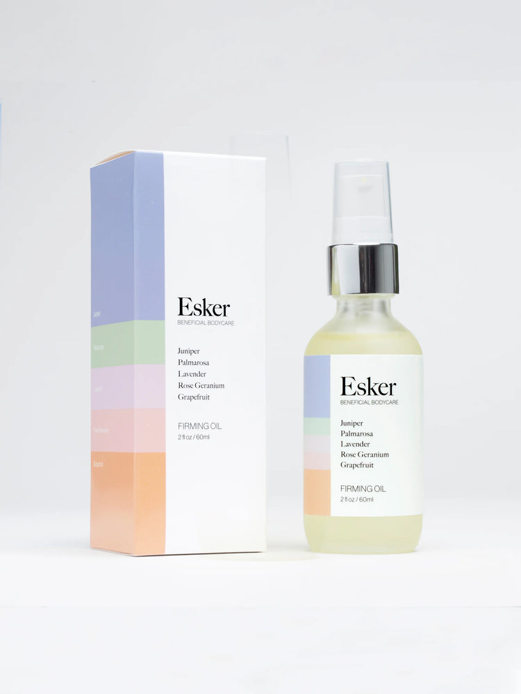 Clear glass bottle with silver top, light yellow oil, & pastel-colored box.