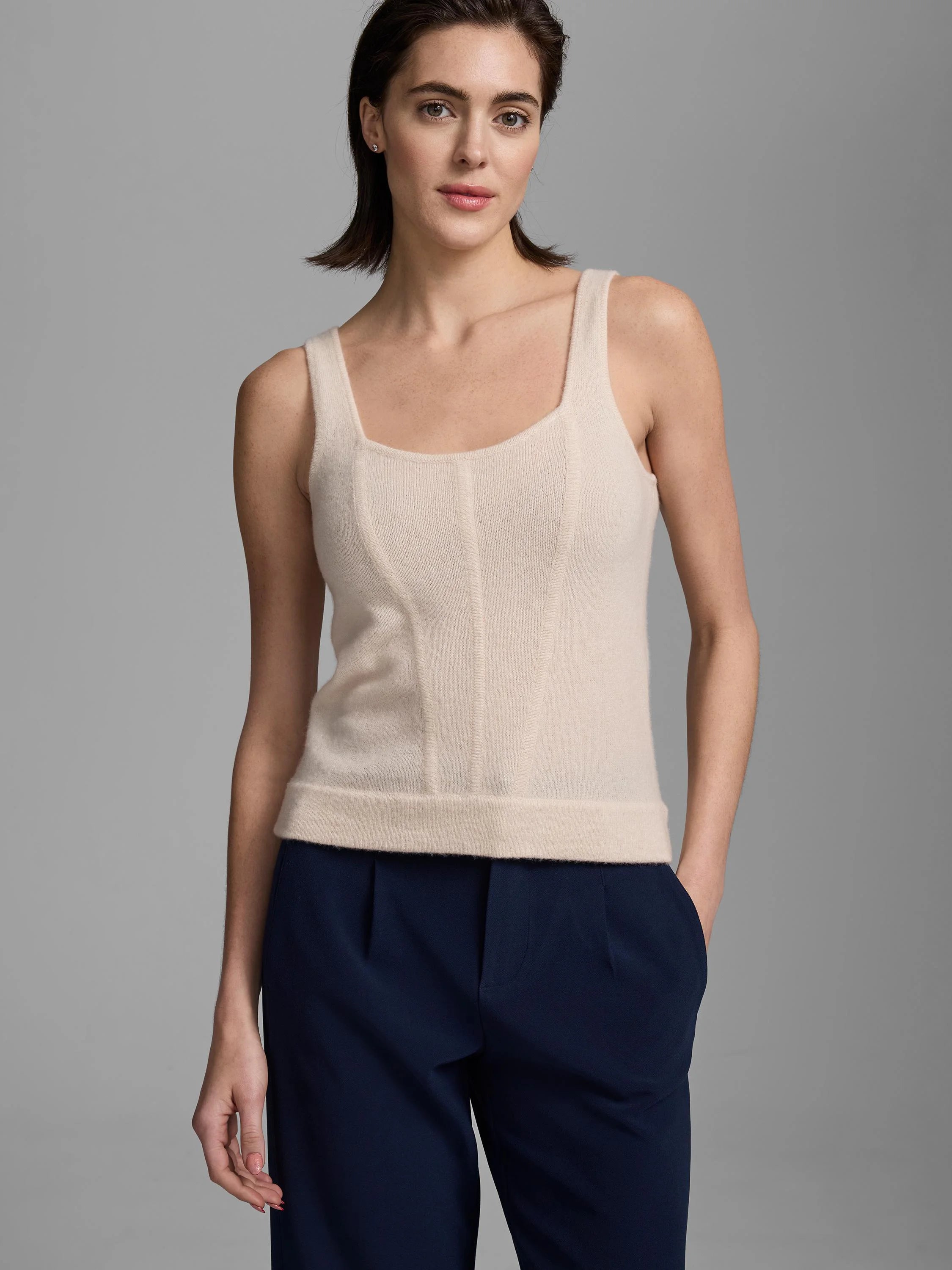 Pale beige cashmere tank with square neck, wide straps, and vertical corset-style ribbed seams.