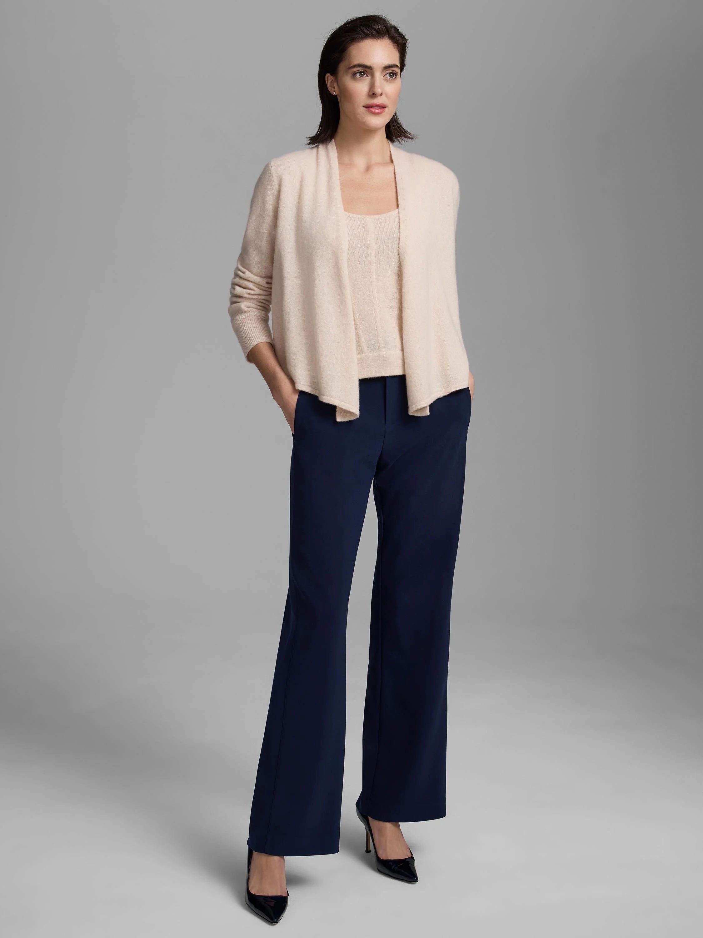 Pale cream knit cardigan with an open, draped front and long sleeves.