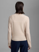 Light beige cashmere cardigan, back view on a model. Features long sleeves, ribbed cuffs and hem.