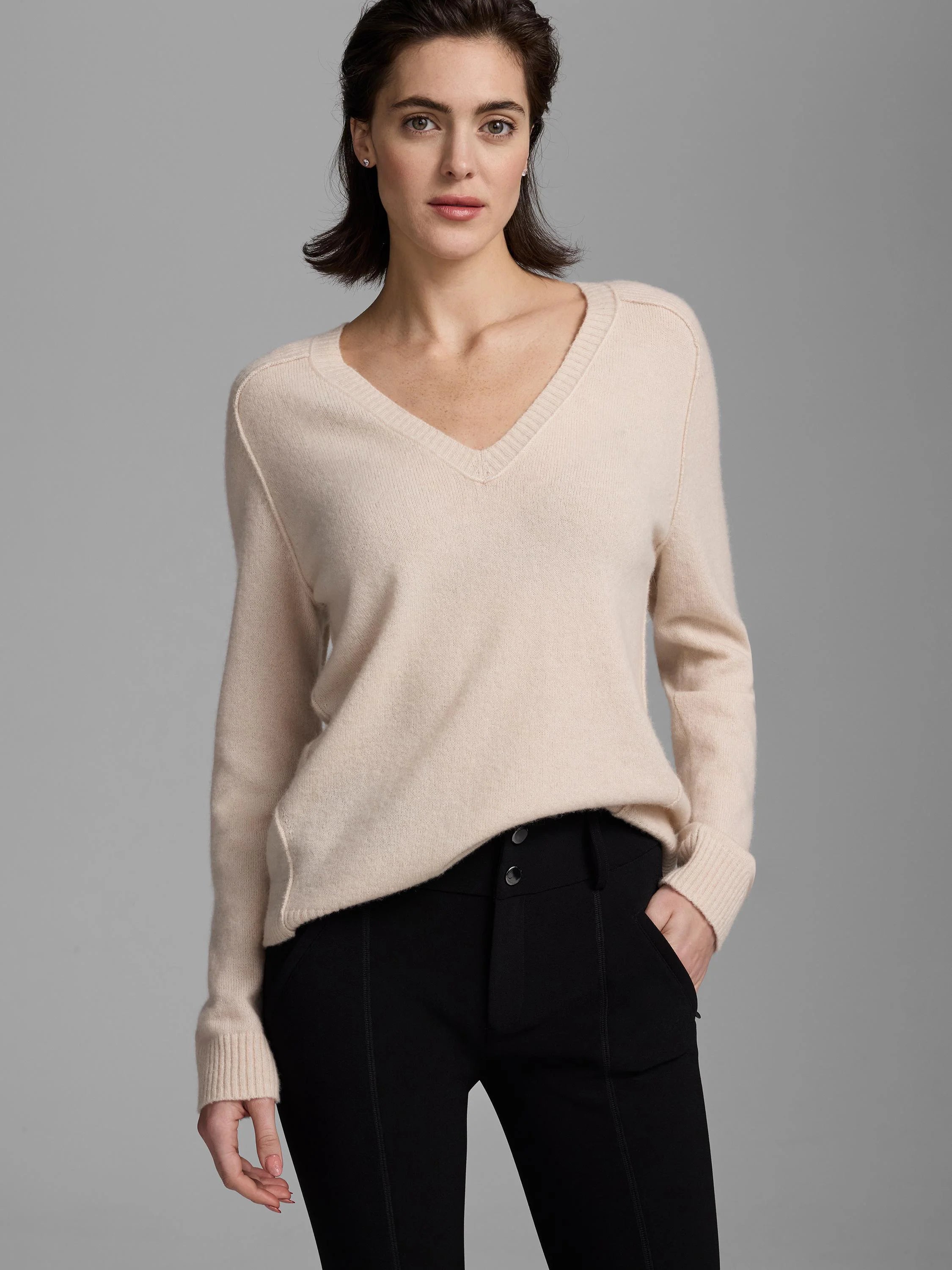 V-neck, relaxed long-sleeve sweater in light beige with ribbed cuffs.