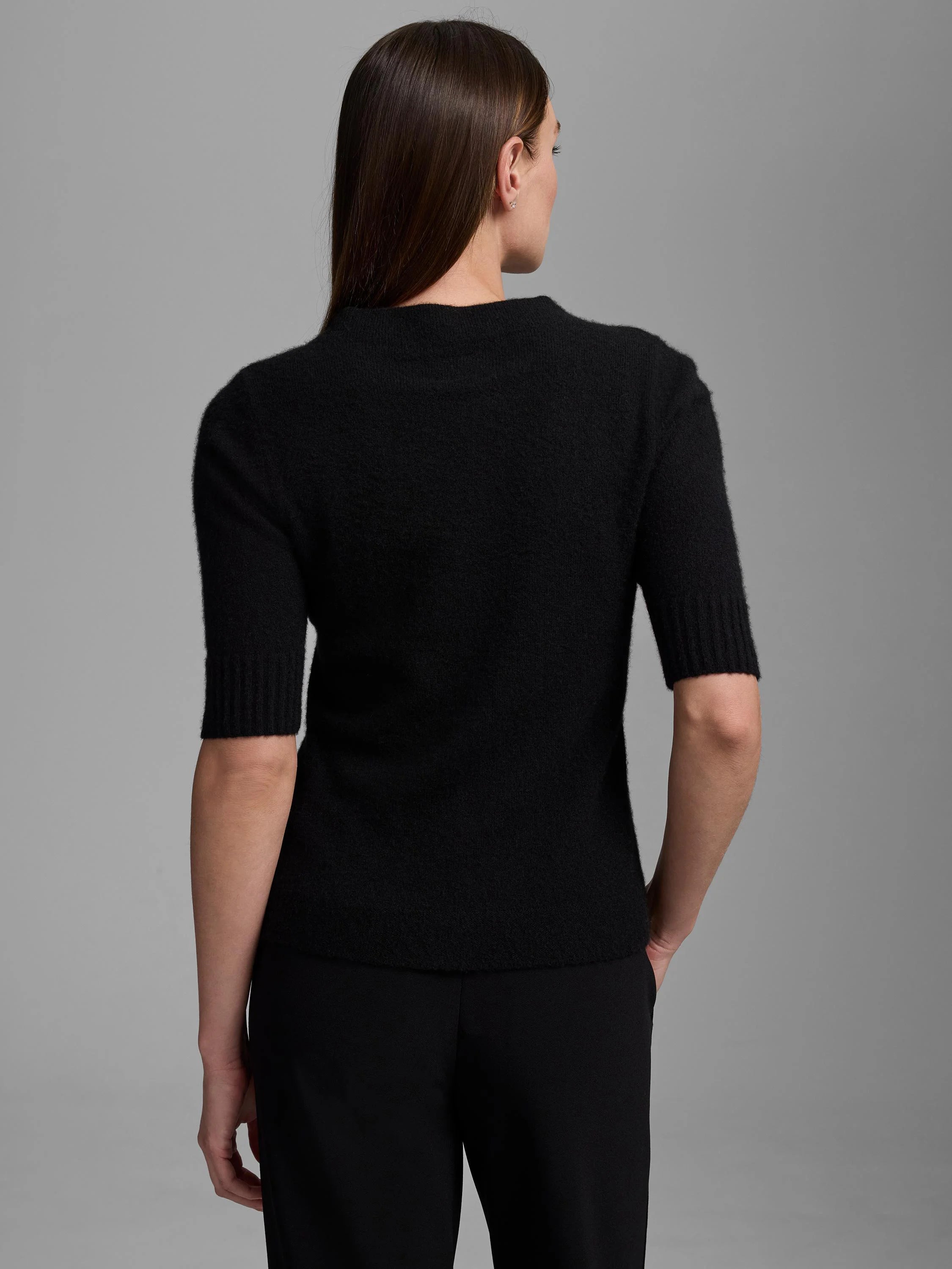 Black mock neck sweater with elbow-length, ribbed sleeves and a soft, fuzzy texture.
