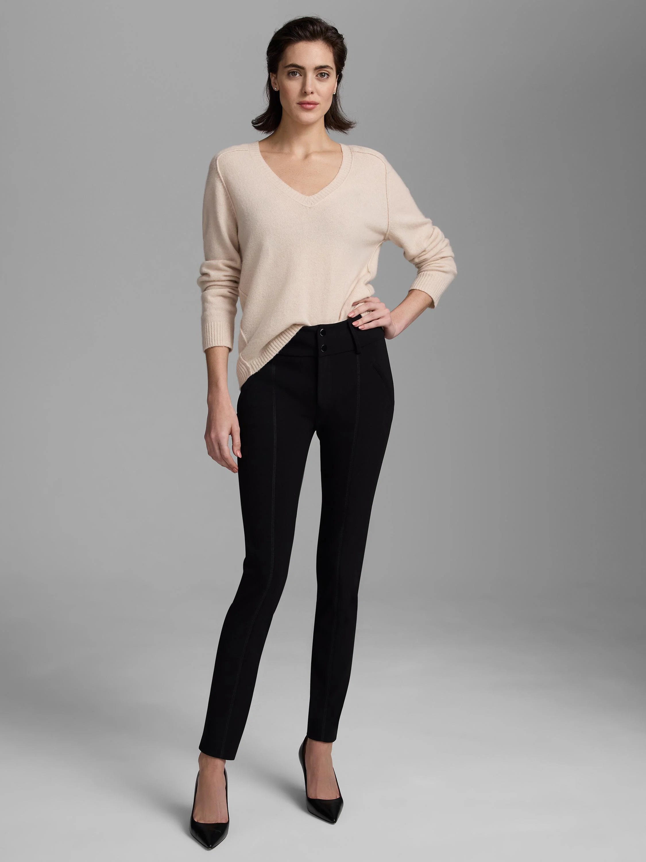 Black knit scuba slim pants with vertical front seams, high waist, and two-button front closure.