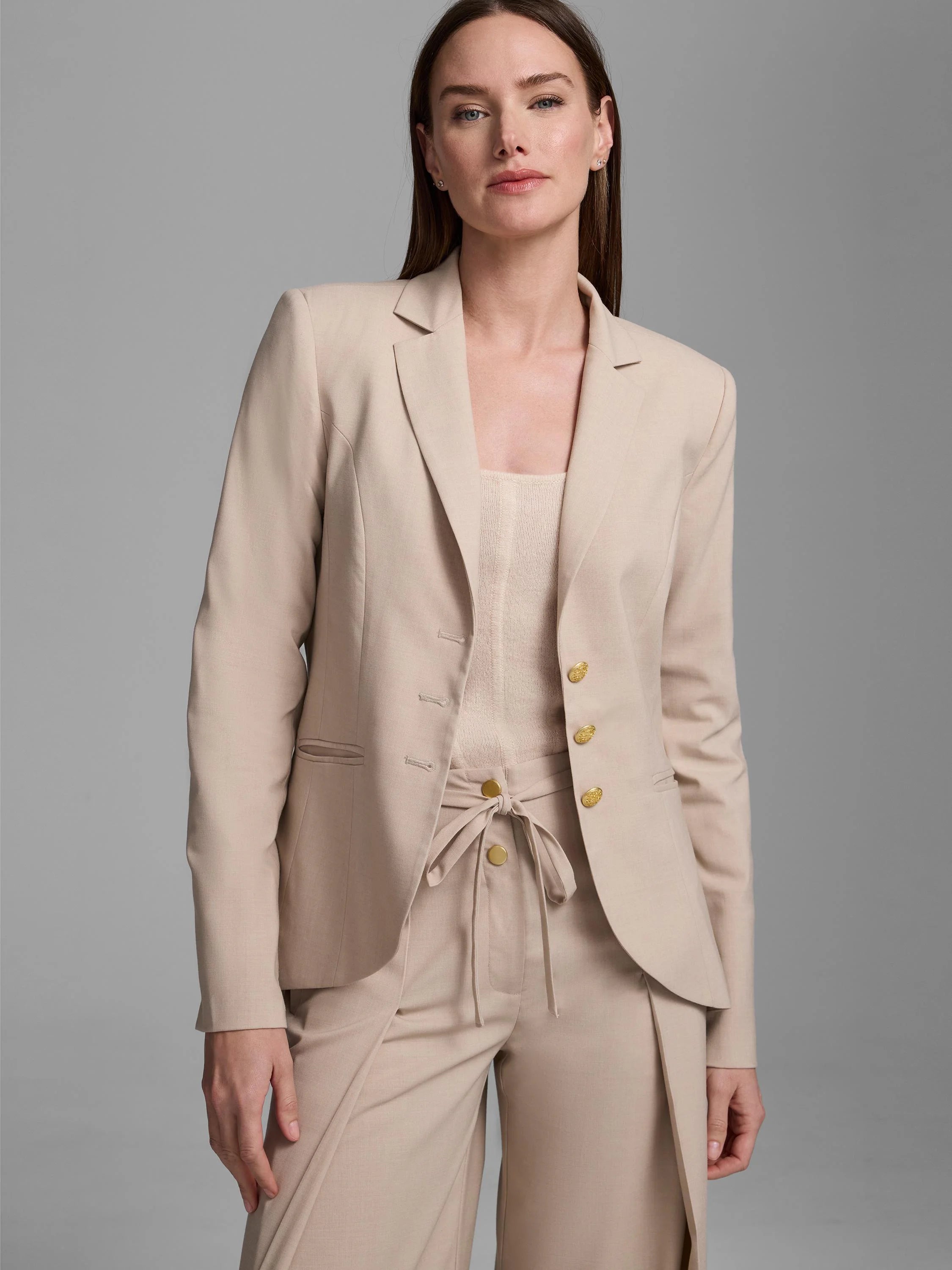 Light beige blazer with notched lapels, ornate gold buttons on the front and cuffs.