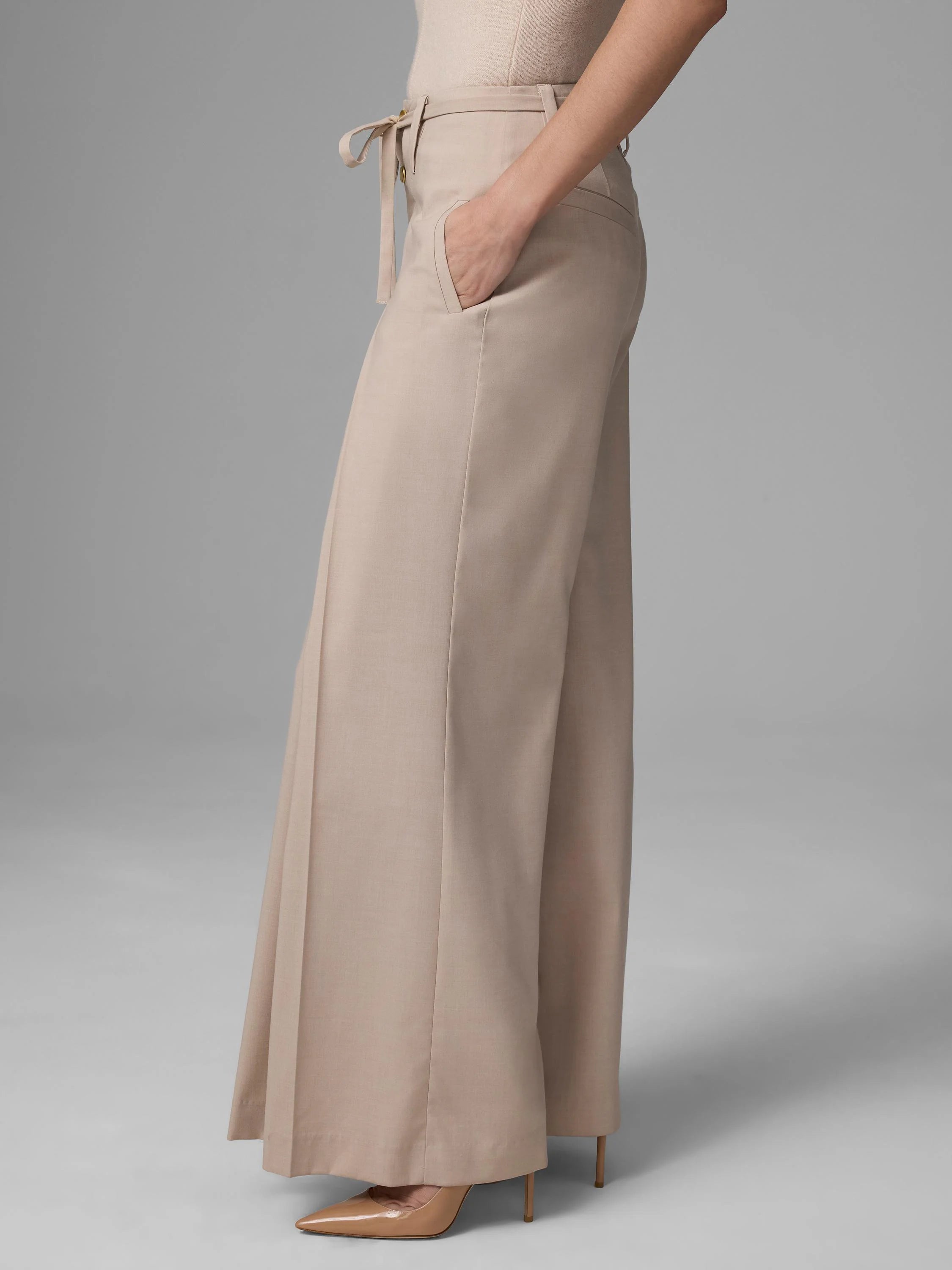 Light beige wide-leg pants with a high waist, self-tie belt, and visible side pocket.