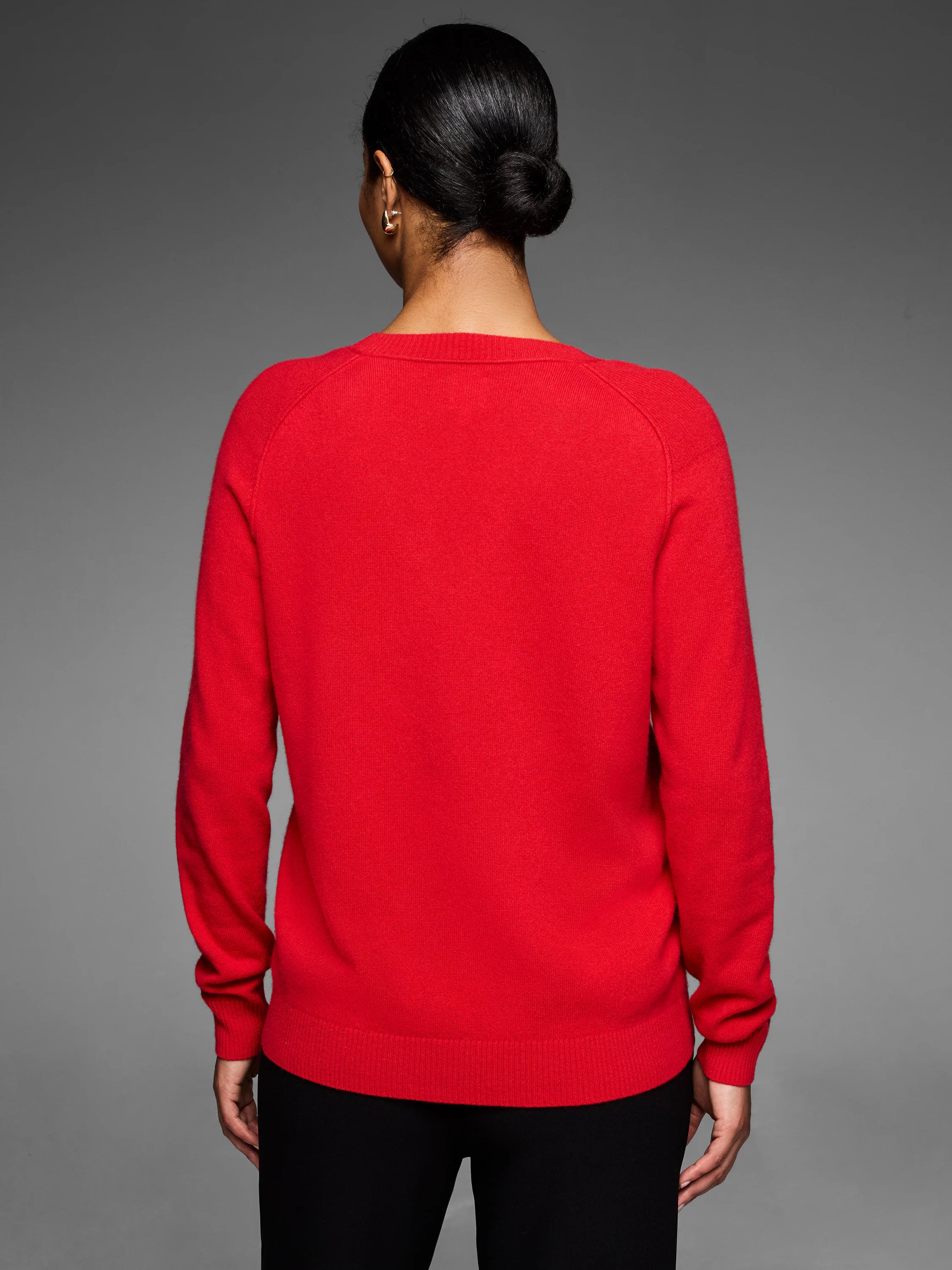 Back view of a red cashmere sweater. It has a ribbed crew neck, raglan sleeves, and ribbed cuffs & hem.