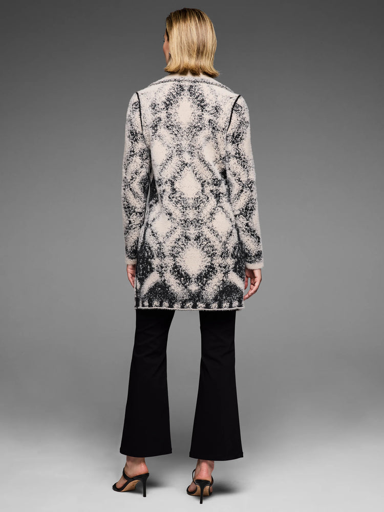 Textured double knit coat, off-white with fuzzy black abstract diamond pattern and dark trim. Mid-thigh length.