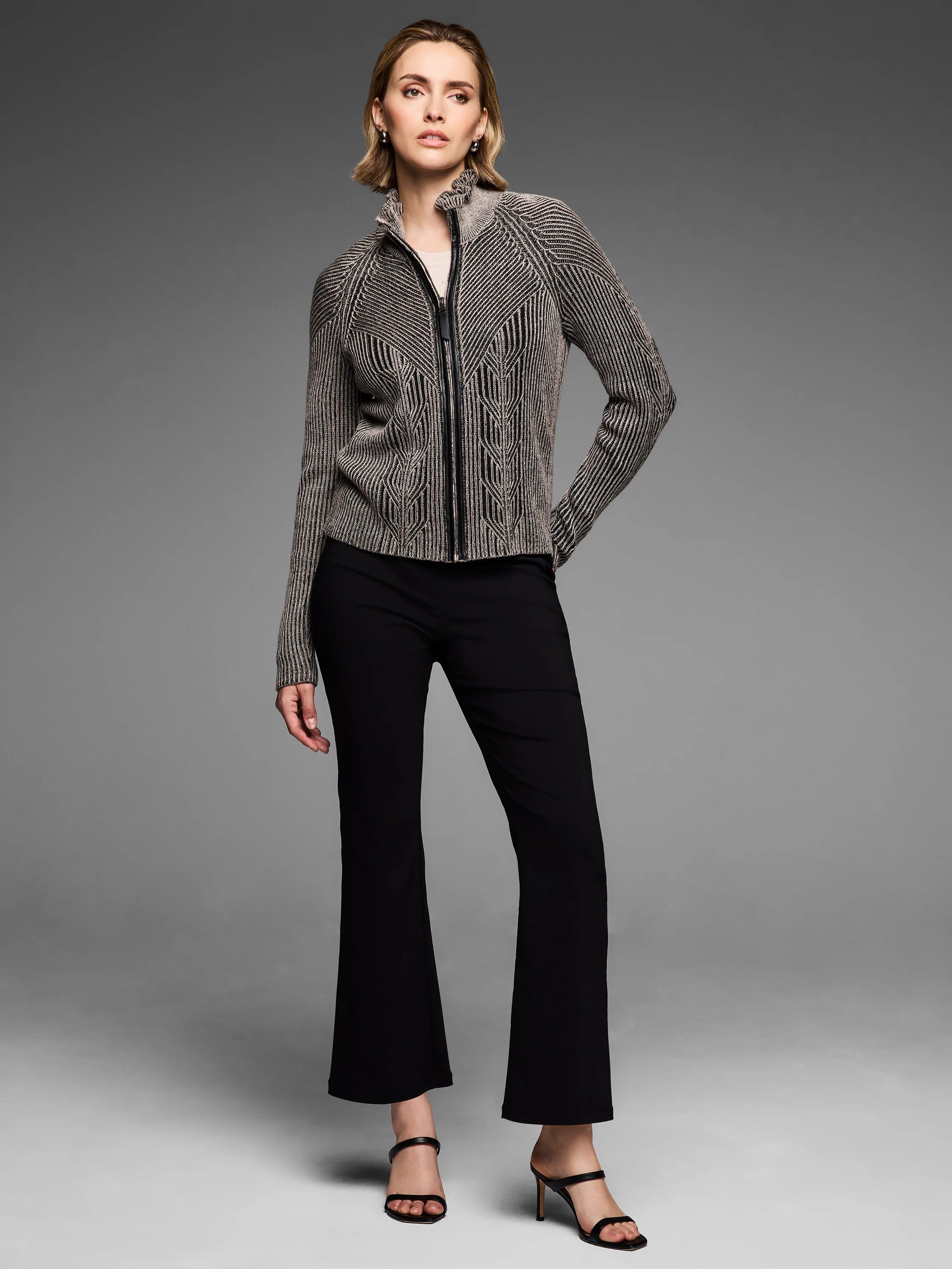 Dark and light patterned knit zip cardigan with a ruffled stand-up collar and engineered stripe and chevron design.