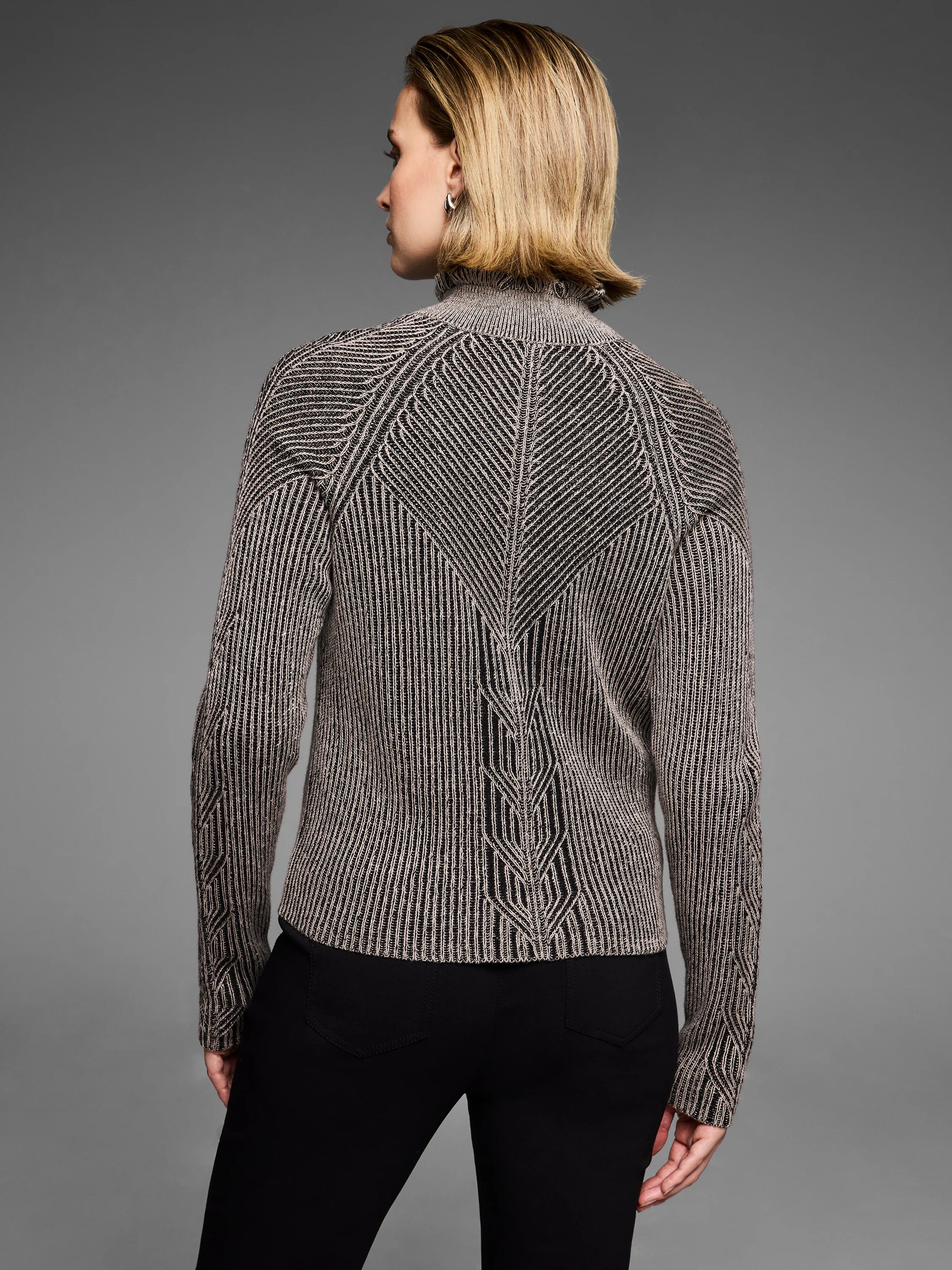 Black and tan knit cardigan with vertical stripes and engineered chevron patterns on the back and sleeves. Ruffled high neck.