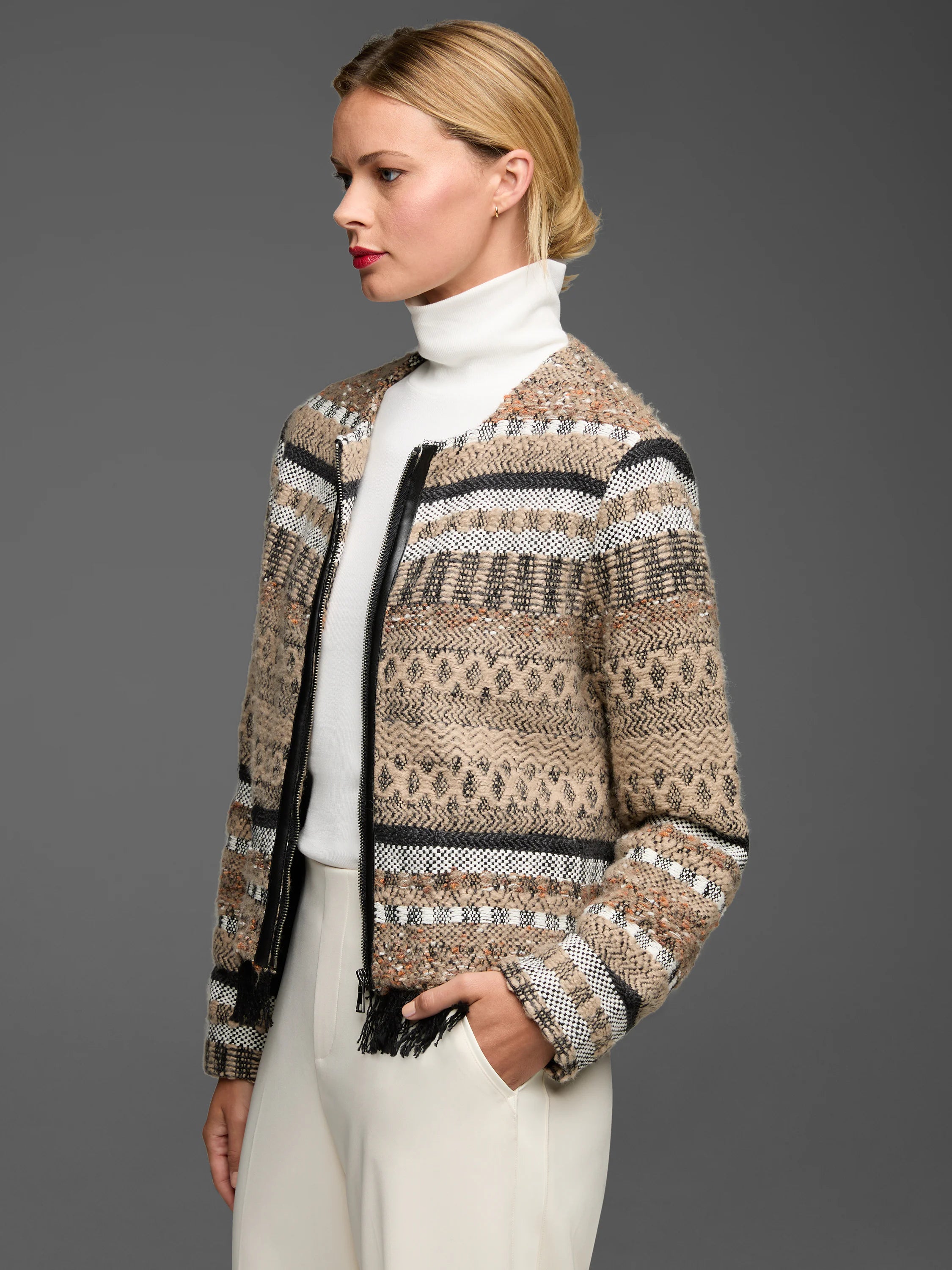 Beige knit jacket with black & white geometric woven patterns, black leather zipper trim, and fringe.