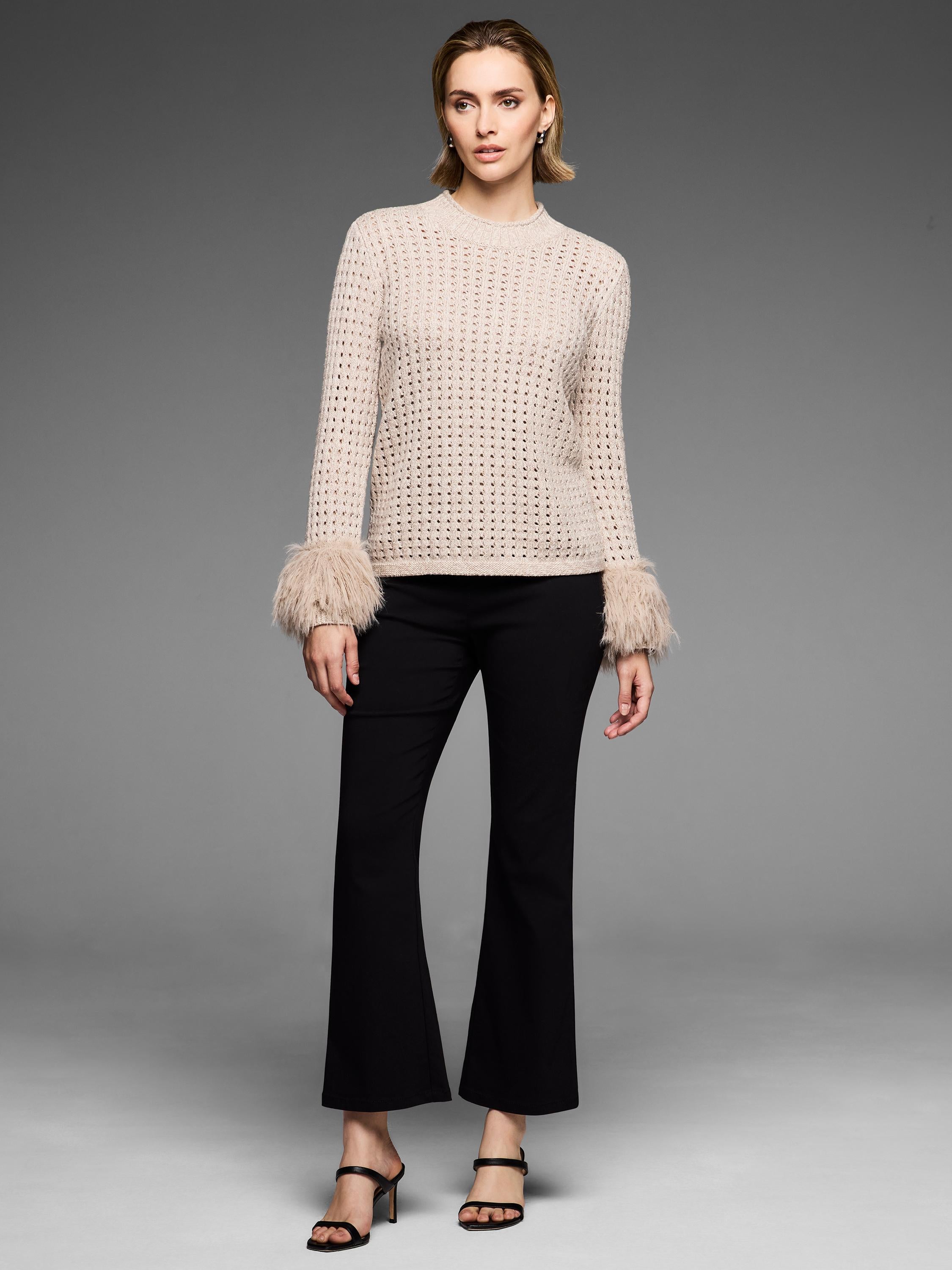 Fitted light beige open-knit sweater featuring a mock neck and dramatic faux fur trim cuffs.