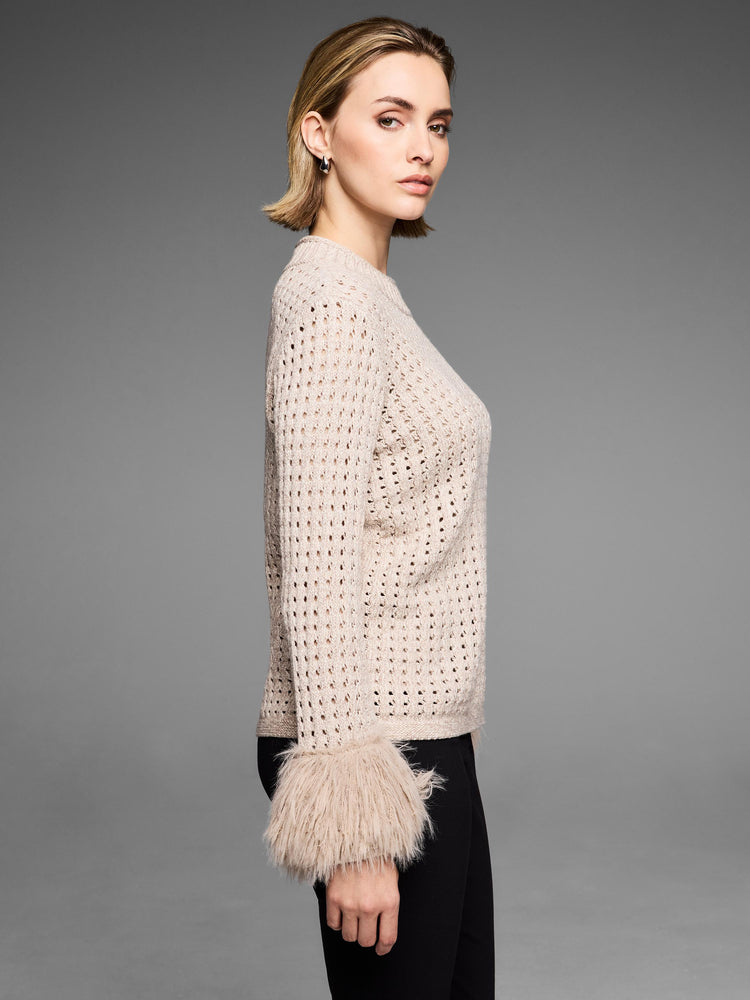 Fitted beige open-knit sweater featuring dramatic shaggy faux fur cuffs on the sleeves.