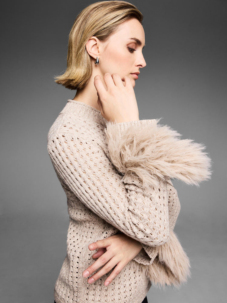 This relaxed taupe sweater has a stylish open-knit construction and is accented by exaggerated fluffy faux fur cuffs.