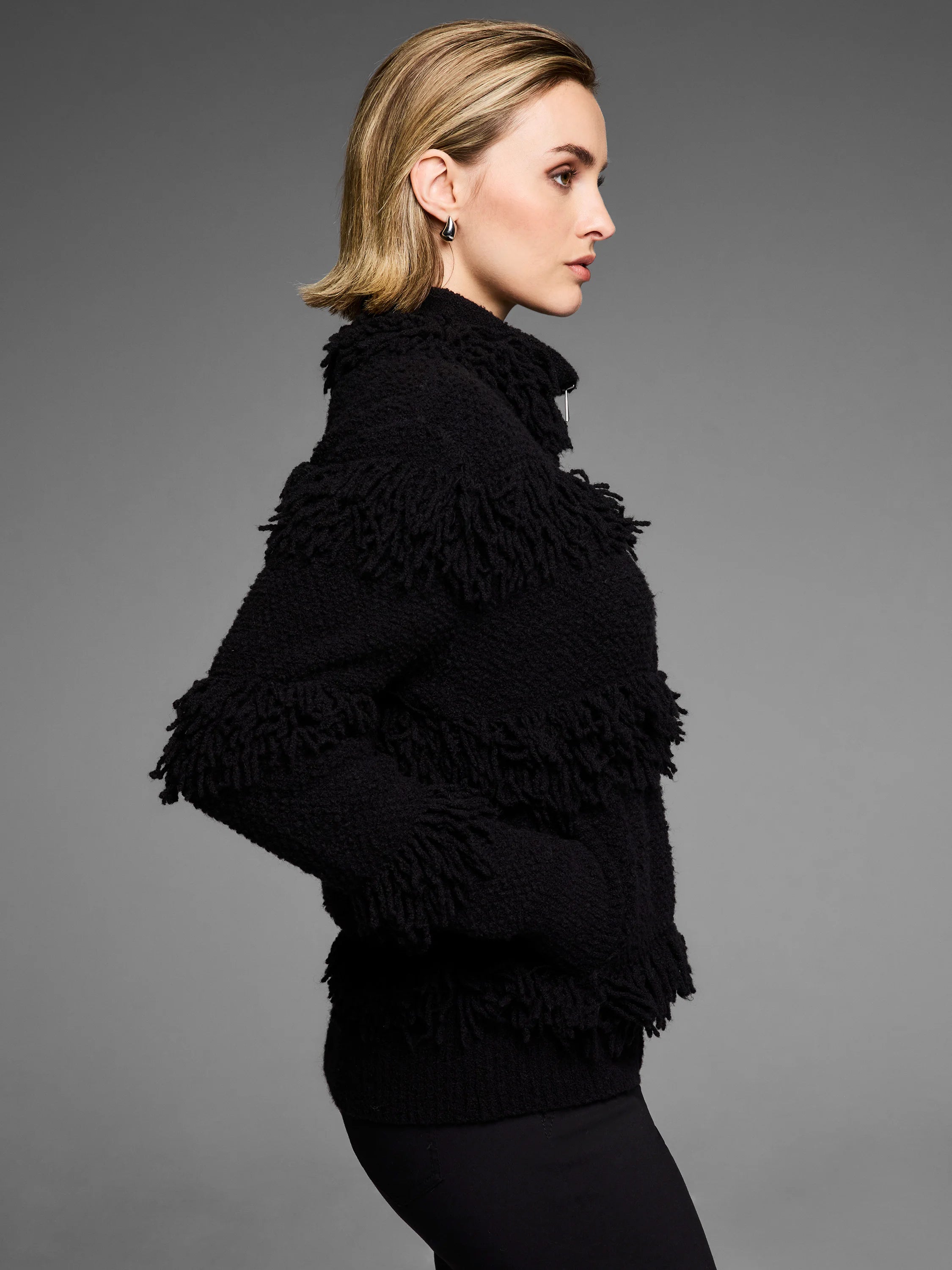 Black jacket with short, dense fringe placed in horizontal rows.