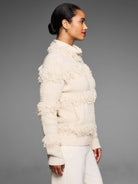 Off-white jacket with horizontal fringe bands, a textured knit, and a high collar.