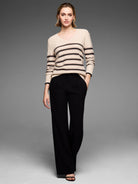 Light beige V-neck sweater with dark horizontal stripes and subtle sparkle flecks.