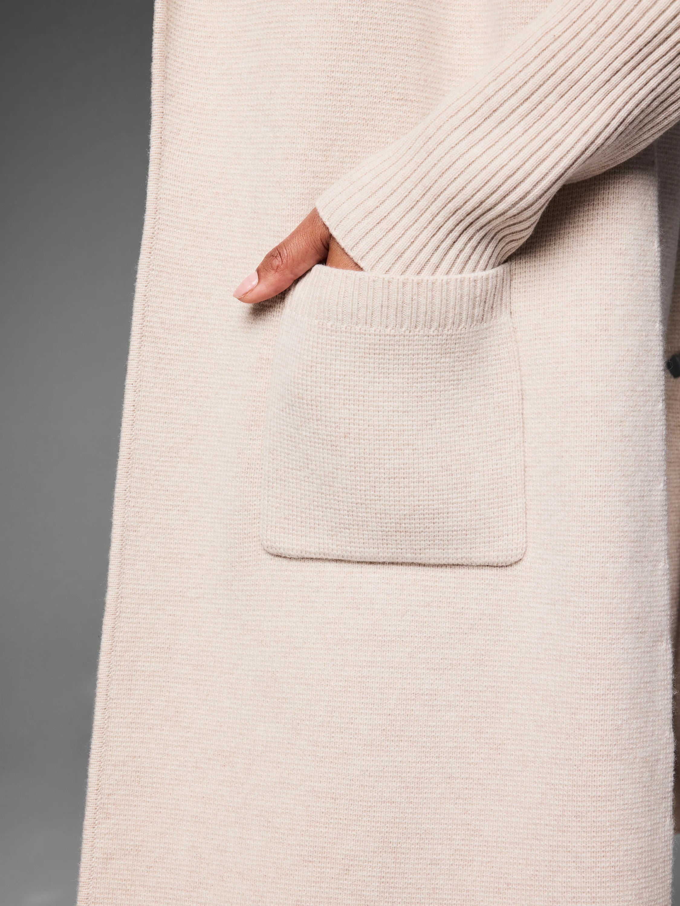 Light beige cashmere blend coat with a patch pocket, ribbed opening, and ribbed sleeve cuff.