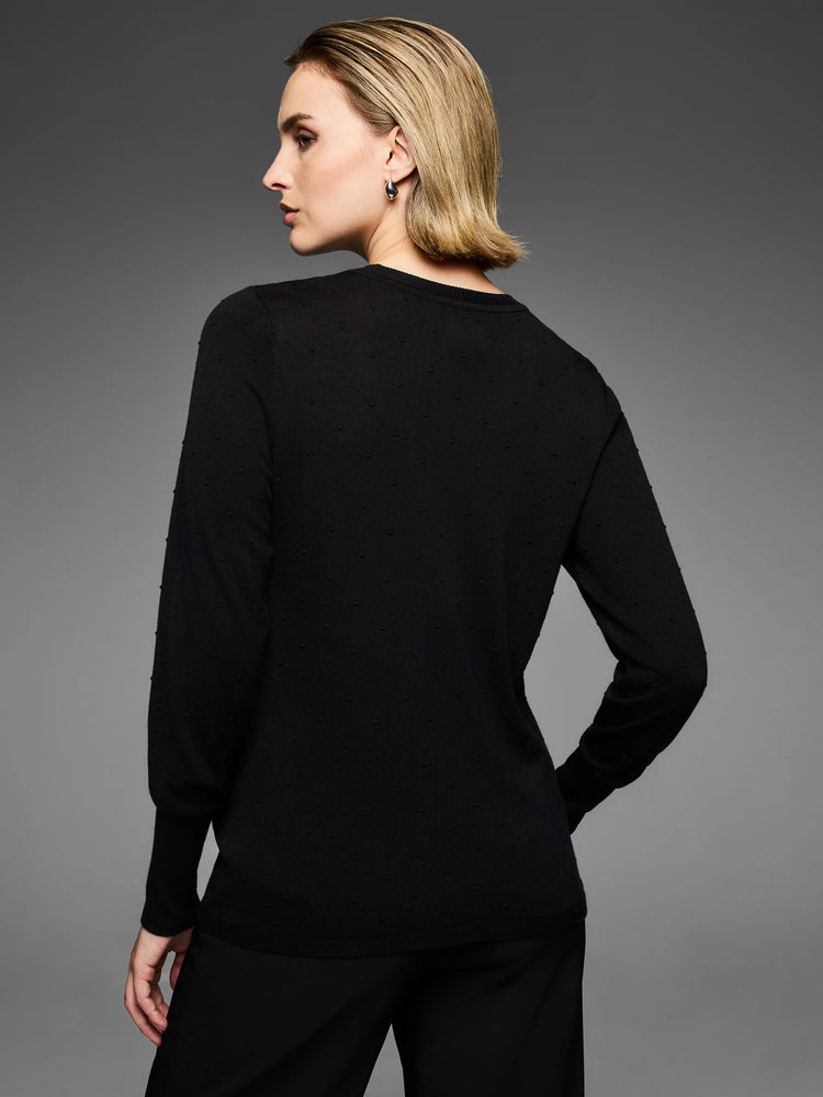 Black round-neck long-sleeved sweater with an all-over dotty texture.