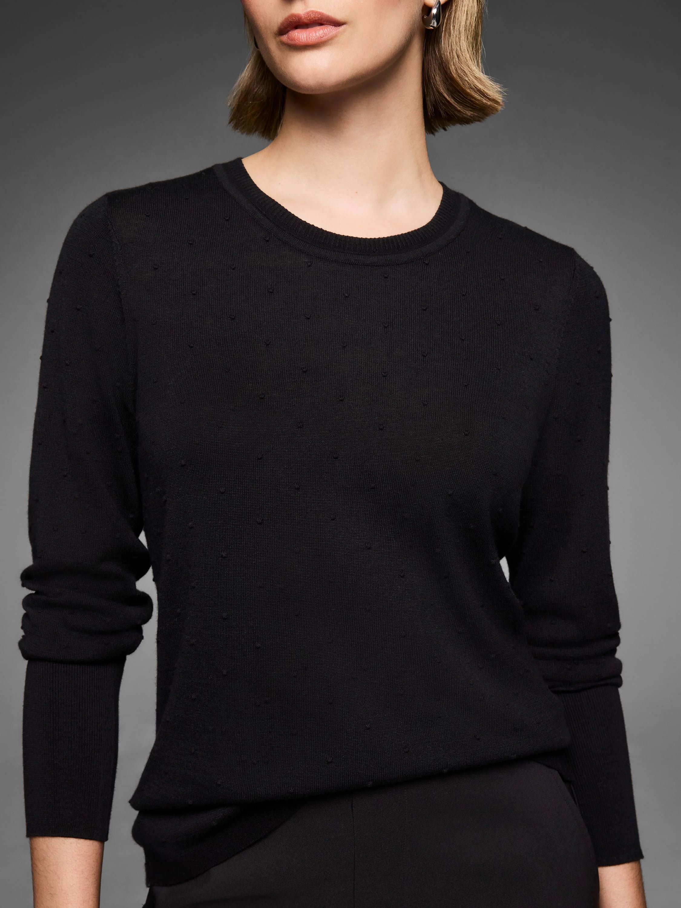 Black crew neck sweater with a subtle raised dot texture.