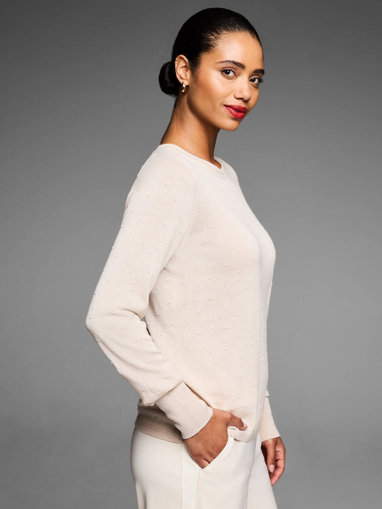 Cream long-sleeve crew neck sweater with a subtle raised dot texture.
