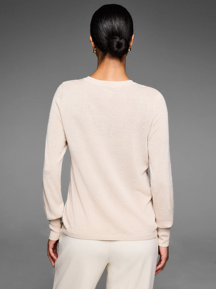 Pale beige sweater with visible raised dot texture covering the garment, worn by a model from behind.