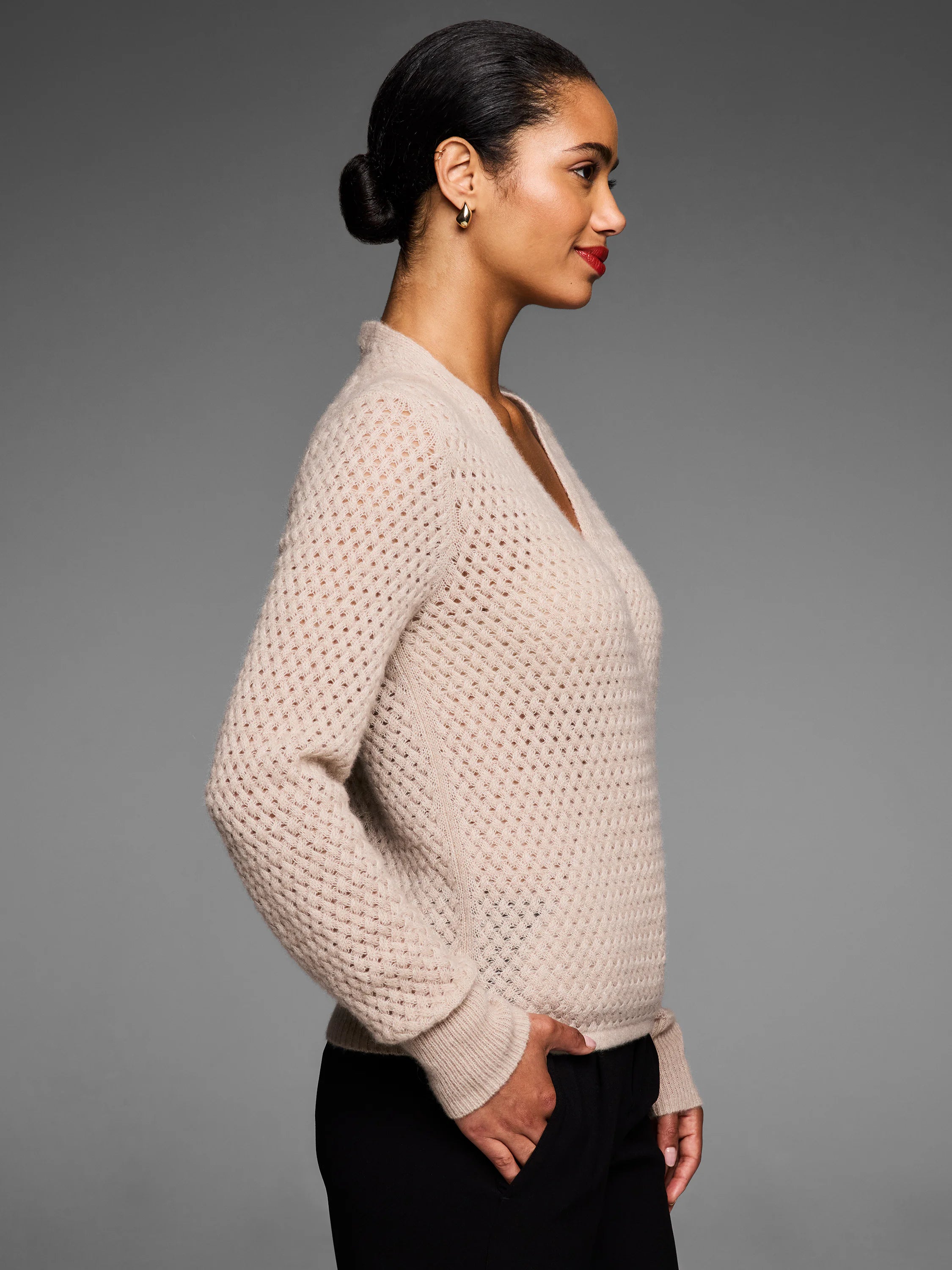 Light beige cashmere pointelle cardigan with a V-neck. Features open knit texture and ribbed cuffs.