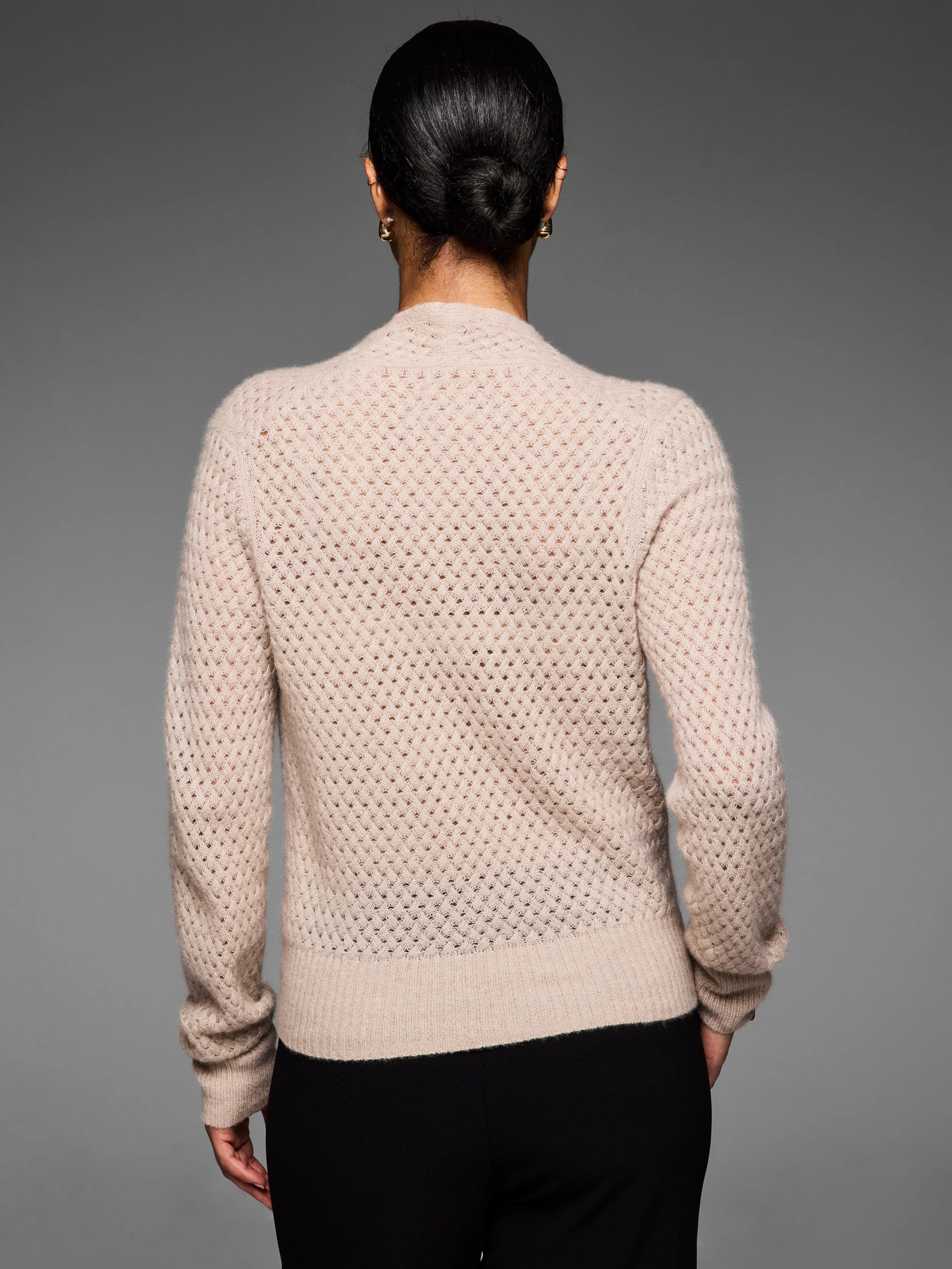 Light beige pointelle cashmere cardigan, back view. Features an openwork knit pattern & ribbed cuffs/hem.