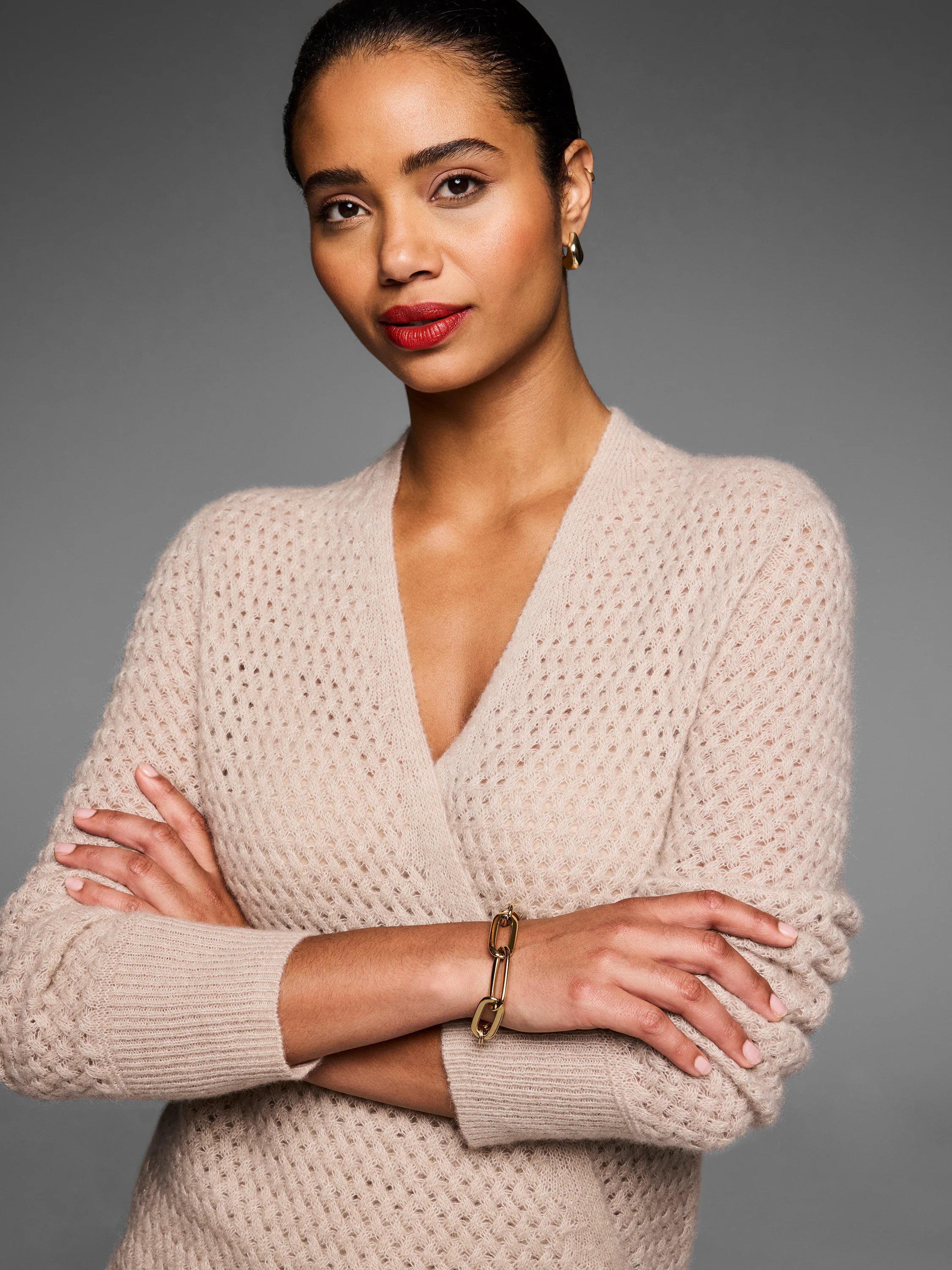 Light beige cashmere cardigan with a pointelle knit pattern, featuring a V-neck and fuzzy texture.