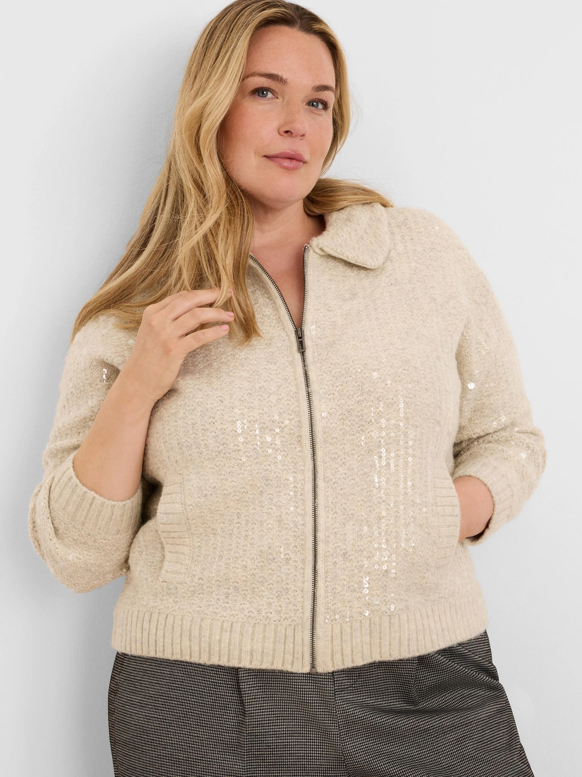 Cream knit jacket with all-over sequins, full zipper, flat collar, and ribbed hem and cuffs.