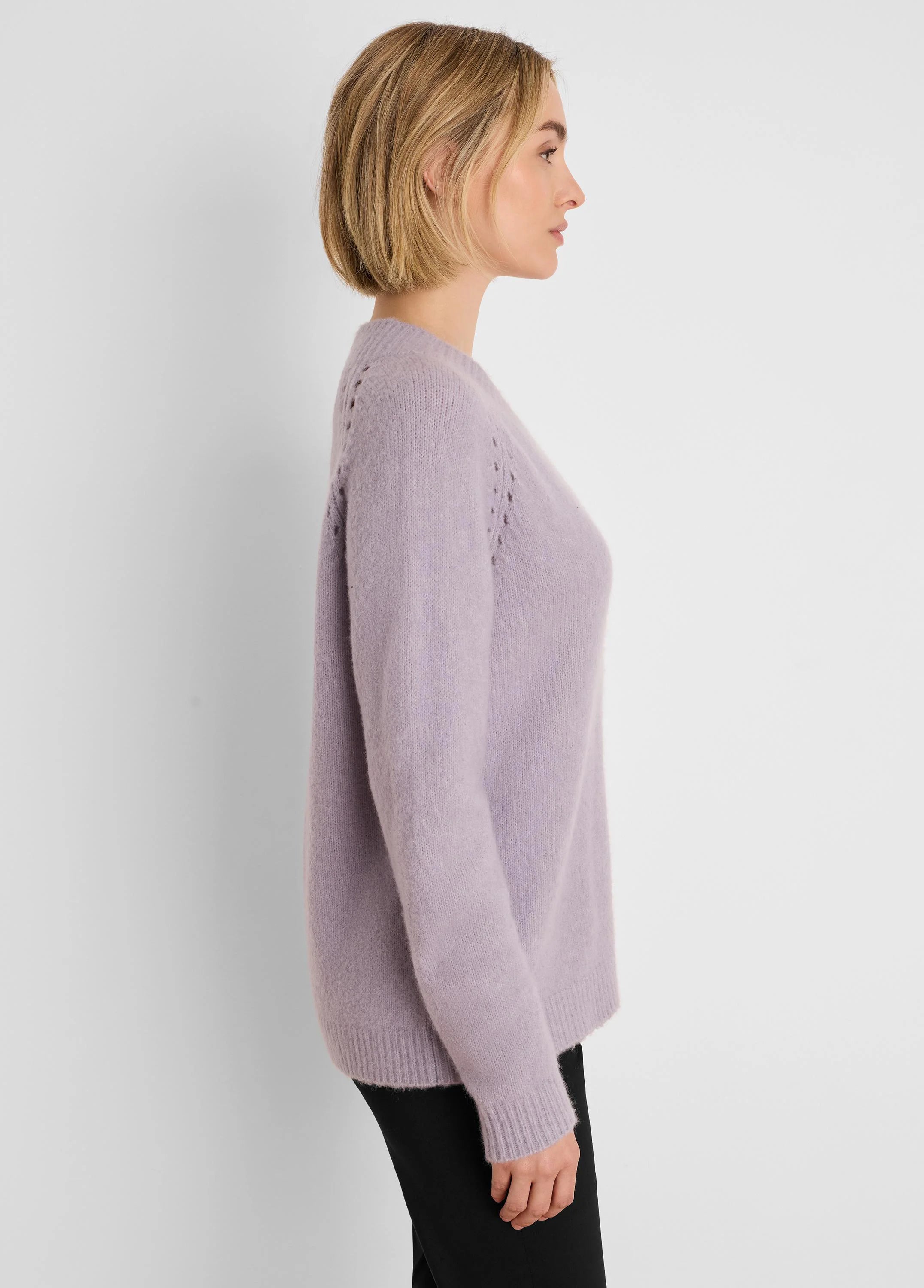 Lavender V-neck sweater with a fuzzy texture, long sleeves, and subtle openwork detailing on the shoulders.