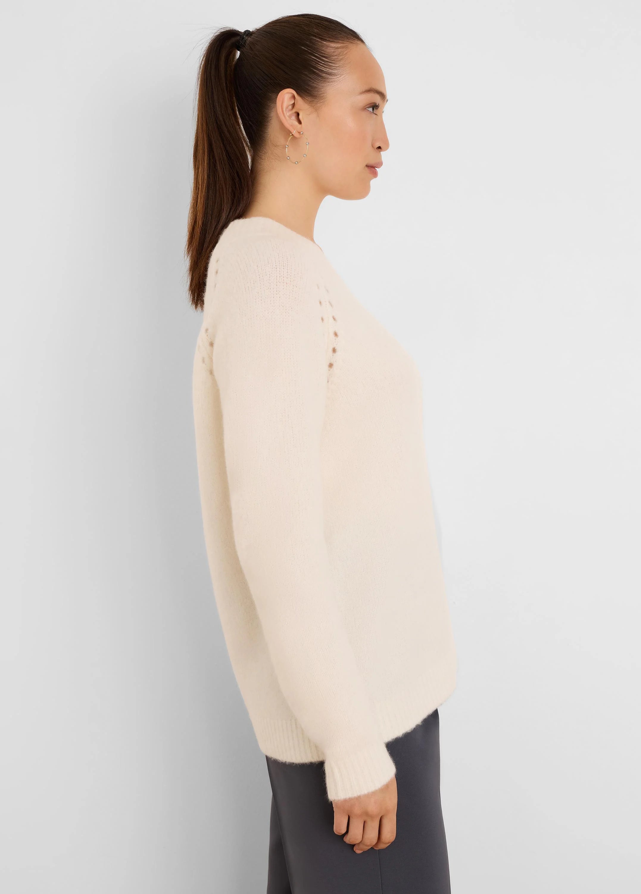 Off-white fuzzy knit sweater with crew neck, dropped shoulders, subtle eyelet detail near shoulders, and ribbed cuffs.