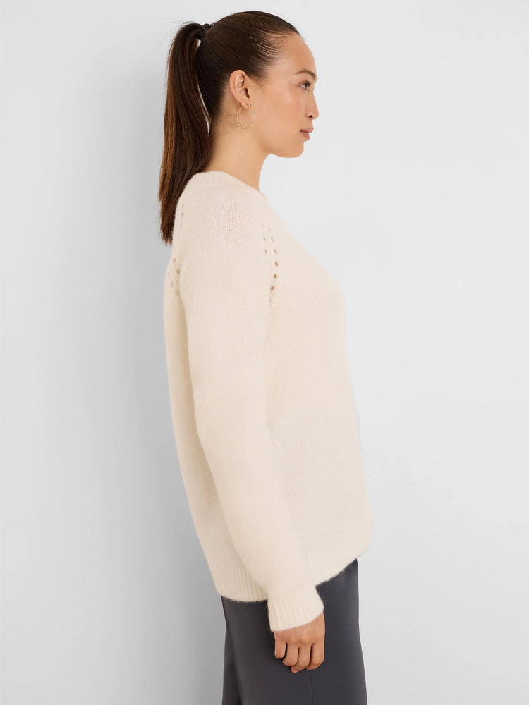 Off-white fuzzy knit sweater with crew neck, dropped shoulders, subtle eyelet detail near shoulders, and ribbed cuffs.