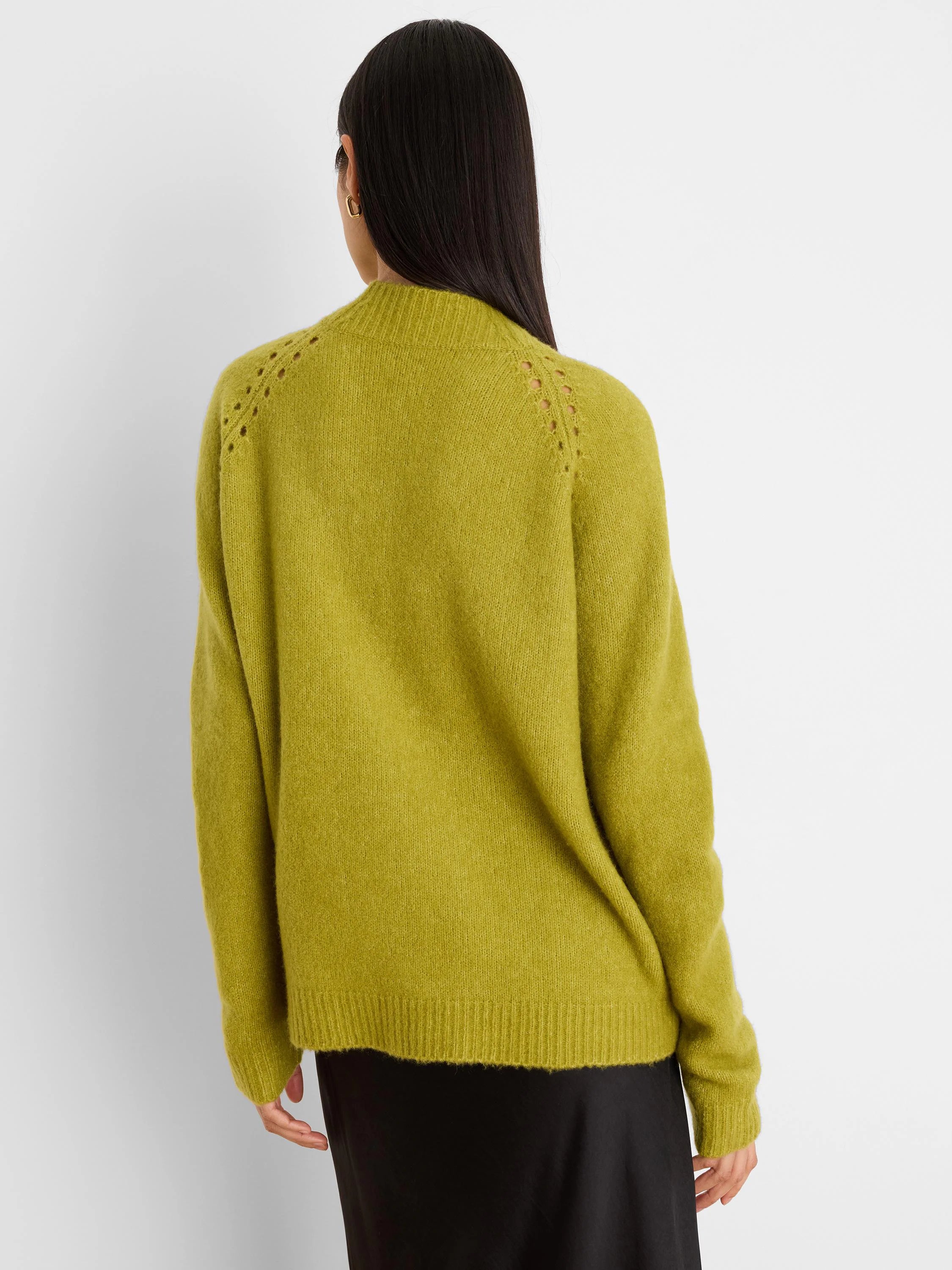 Chartreuse green fuzzy sweater, seen from behind. Features open-knit shoulder details, ribbed cuffs and hem.