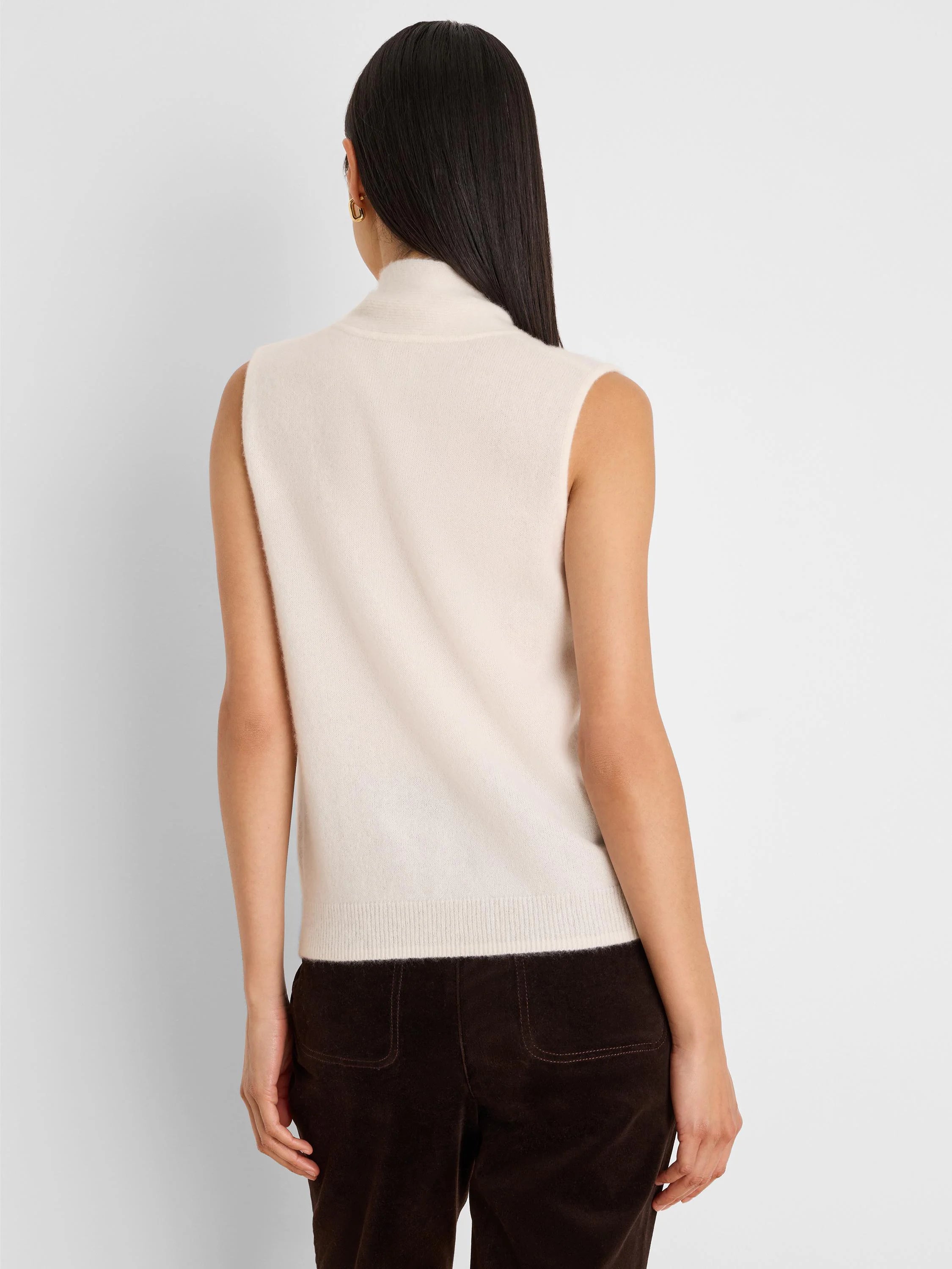 Cream sleeveless mock neck tank with ribbed hem, shown from the back. Soft, fuzzy texture.