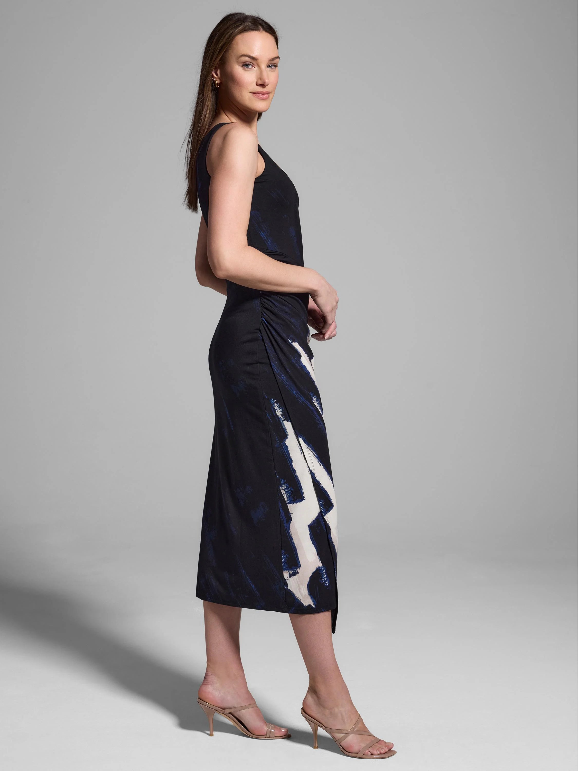 Black midi dress with abstract blue and off-white brushstroke pattern. Ruched detail at waist. Sleeveless.
