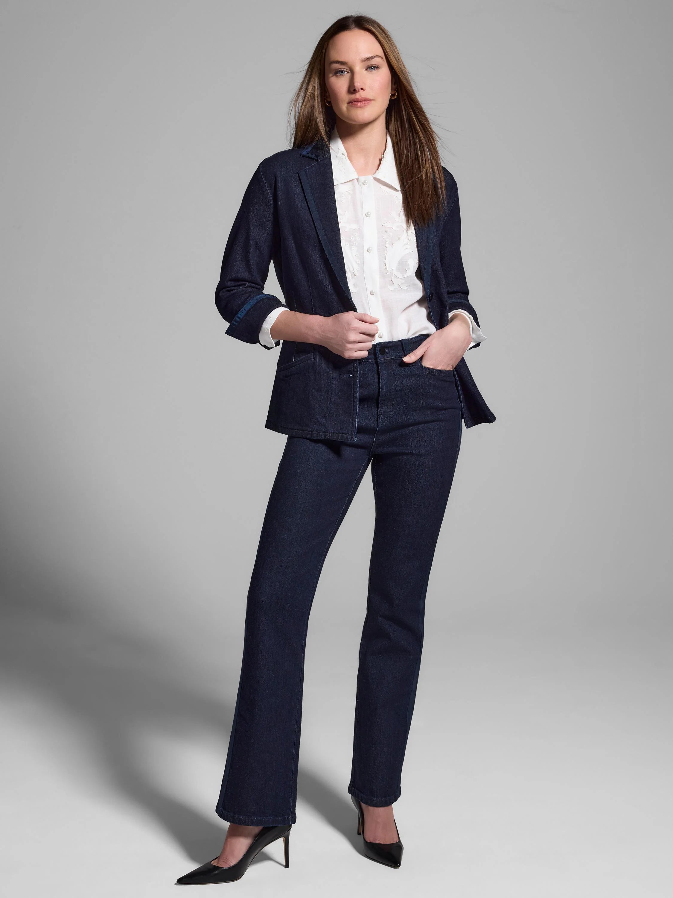 Dark wash denim blazer with gold trim; cuffs and lapels show contrast stitching. Model also wears white shirt and dark...