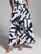 White pleated maxi skirt with a dark blue and black abstract print.  Center front slit.